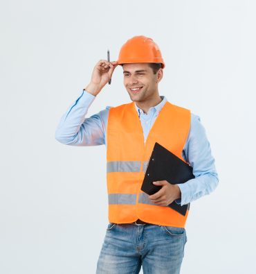 Smiling construction engineer posing isolated over grey background.